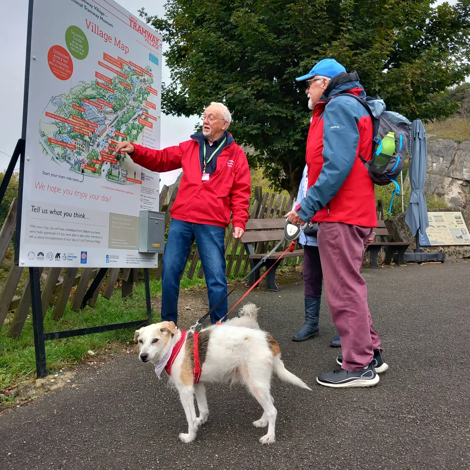 A museum volunteer helping a visitor at the village map